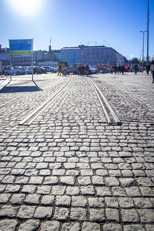 在芬兰赫尔辛基，阳光明媚的下午，有铁轨的鹅卵石路开始/结束。